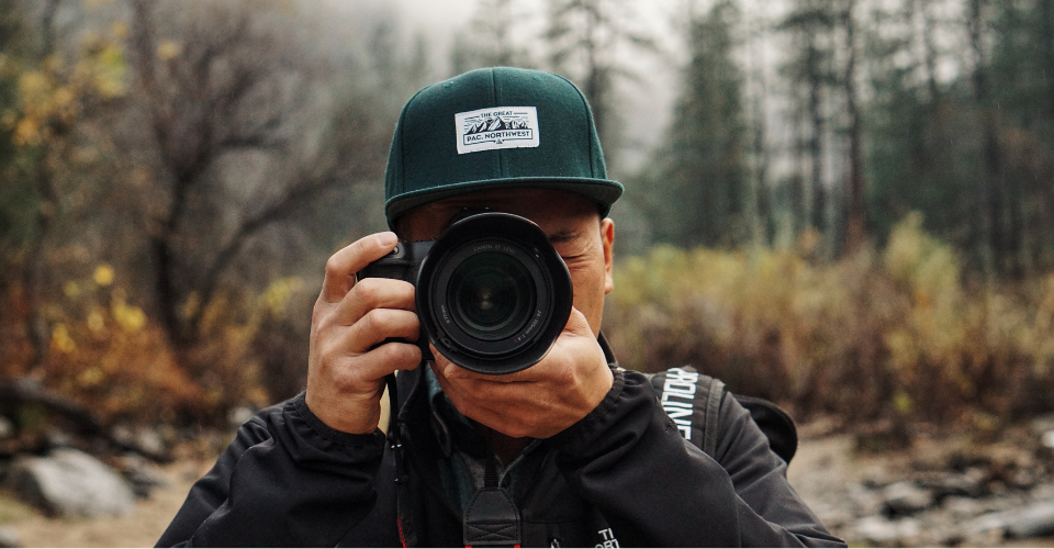 Man with a camera that cover his face.