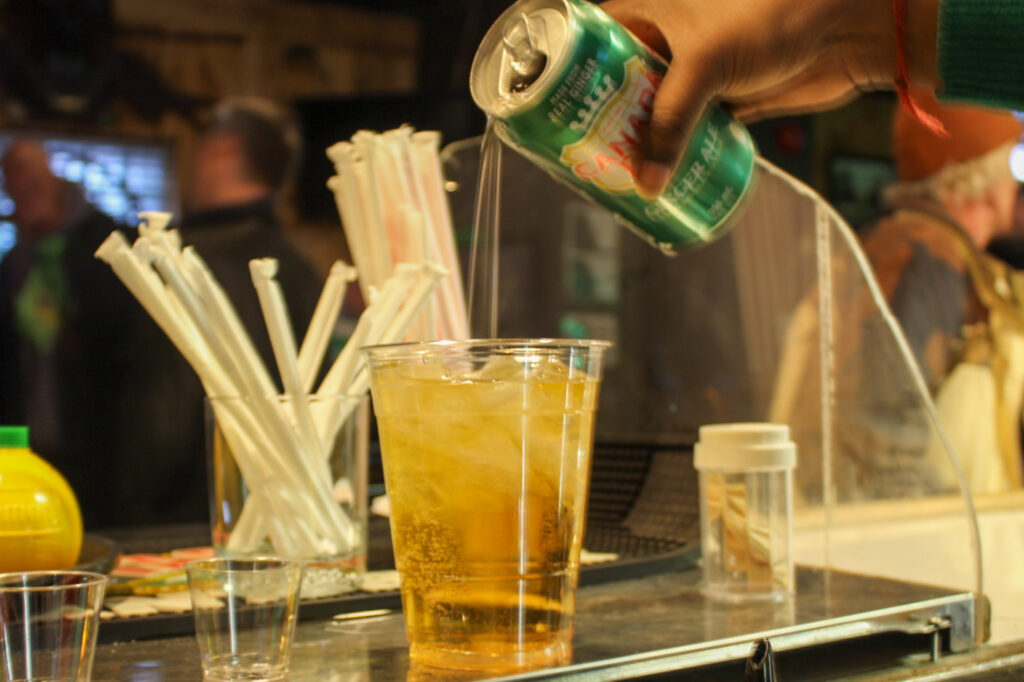 Someone is serving a drink from a can to a glass. 