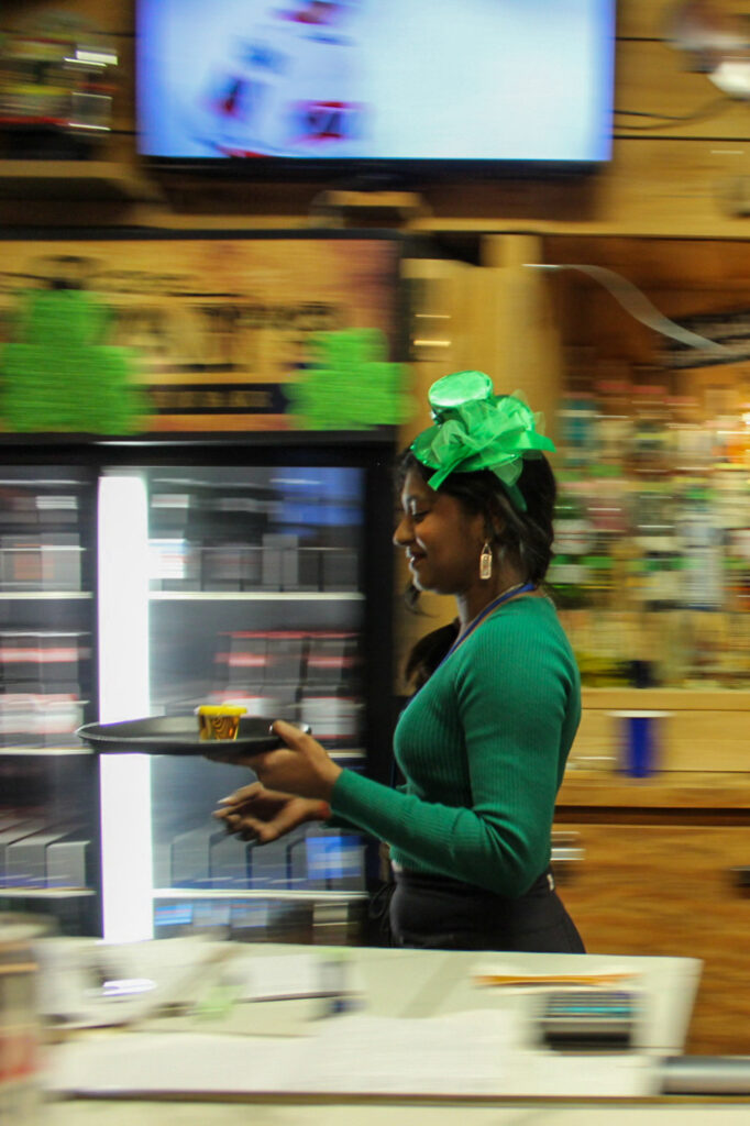 A server run in a bar. She is holding a trail