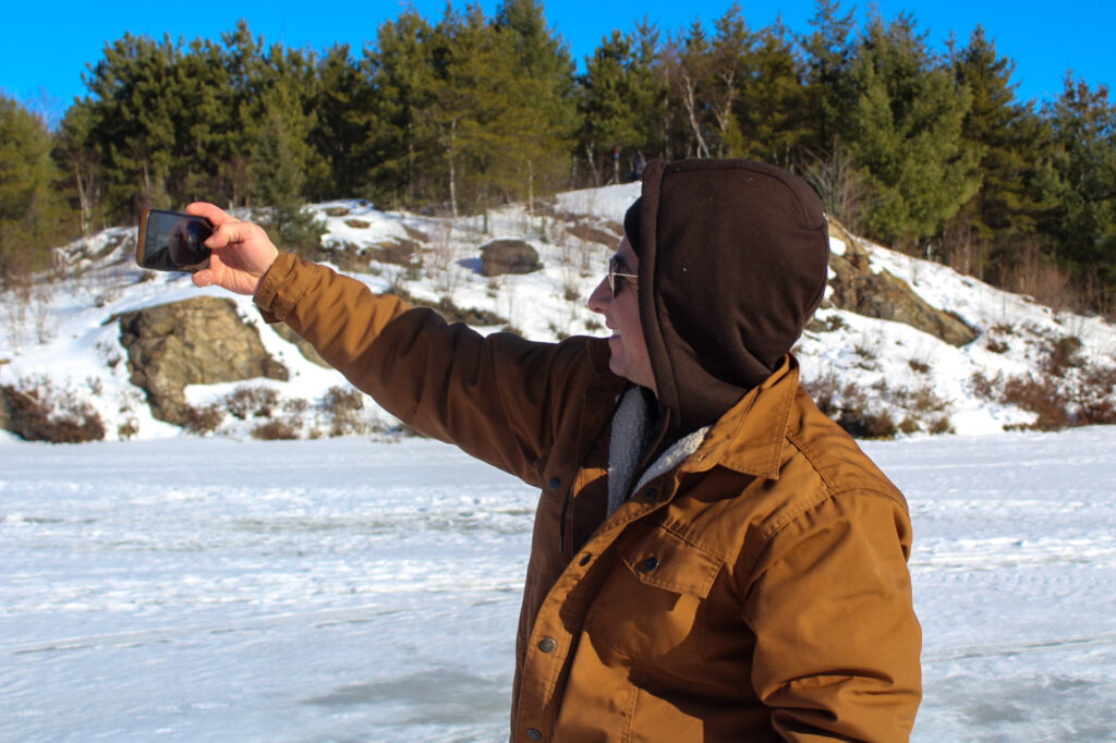 Men is taking a selfie un a frozen lake in Sudbury, Ontario. 